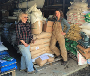 Two women stand in front of a stack of amendment bags