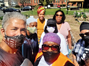 A group of people wearing masks gather in front of the camera