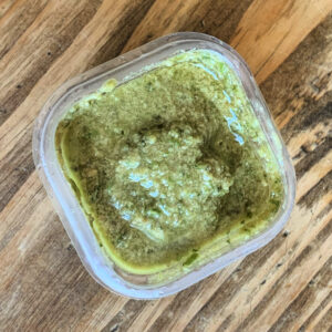 Green garlic scape pesto in a square container