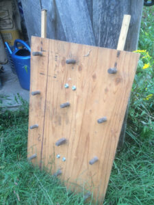 A dibble board, plywood with wooden pegs sticking out of it