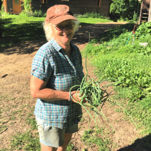 A person holding garlic scapes