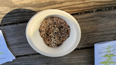 A bowl of chopped, dried burdock root on a picnic table